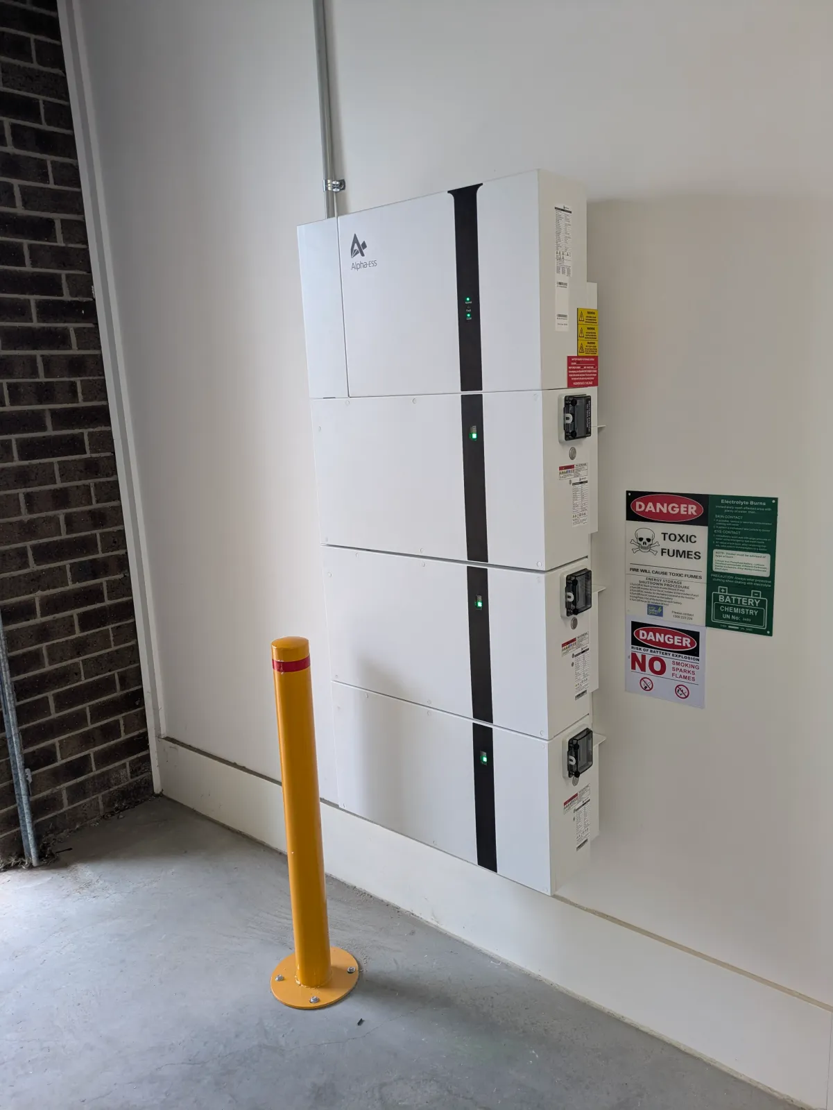 A stacked home battery installed against an external wall