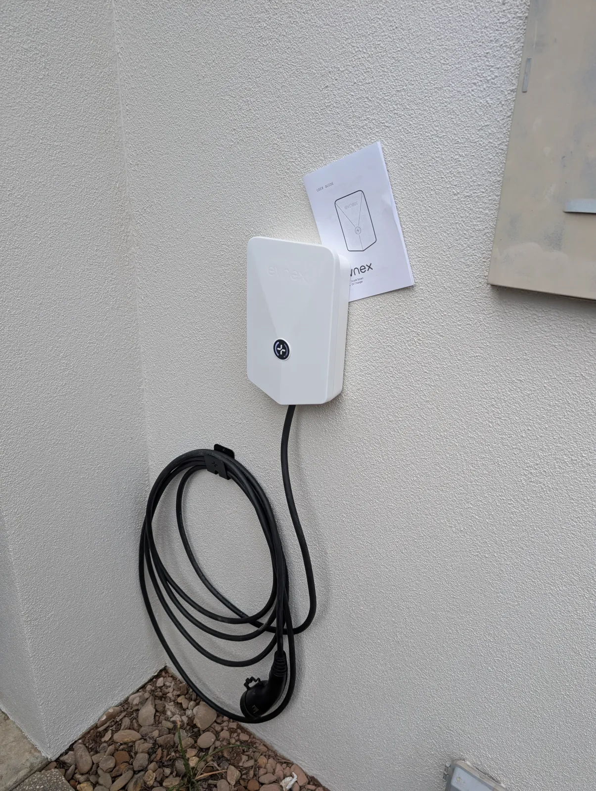 An Evnex charger on a white wall, commissioned