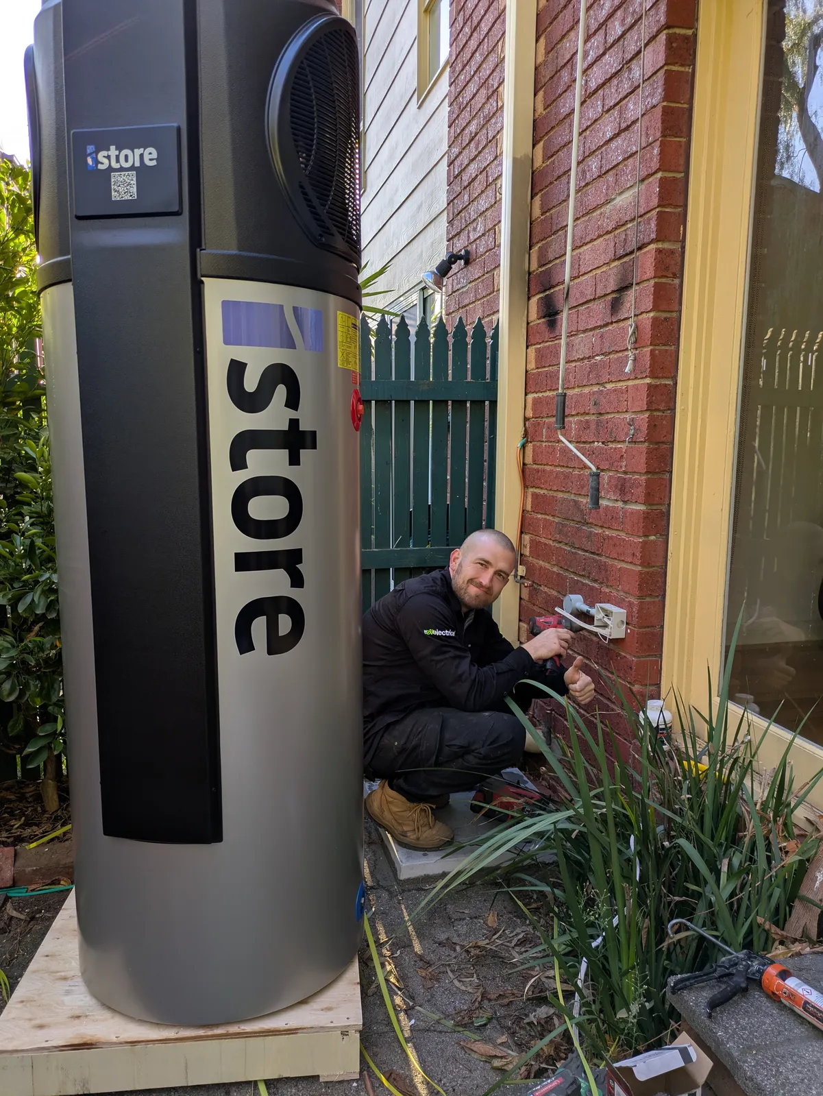 A Revelectrical electrician wiring the isolator beside a new iStore unit waiting to go in